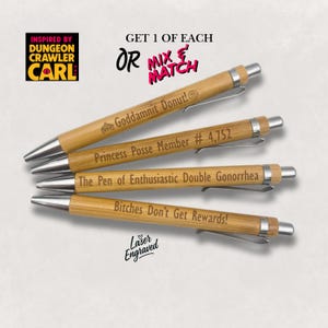 May include: Four bamboo pens with silver accents and engraved text. The pens have various phrases, including "Goddamnit Donut!" and "Bitches Don't Get Rewards!" The image also includes the text "Inspired by Dungeon Crawler Carl" and "Laser Engraved."