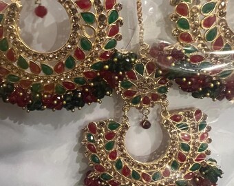 May include: Gold-toned earrings with red, green, and clear gemstone accents. The earrings feature a crescent-shaped design with dangling beads and a chain. The jewelry is likely for special occasions.