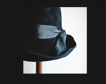 May include: A dark blue felt hat with a wide brim and a blue ribbon tied in a bow.