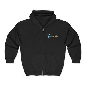Puede incluir: Una sudadera negra con cremallera, capucha, mangas largas y dos bolsillos delanteros. En la parte superior izquierda del pecho, la palabra HEARTSTOPPER está impresa en una fuente multicolor de estilo manual, rodeada de pequeños detalles gráficos.