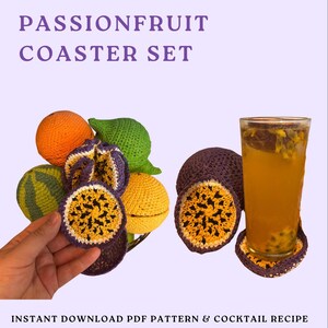 Op de afbeelding: Een passievrucht onderzetter set met een glas passievruchtensap. De set bevat gehaakte onderzetters en fruitvormige decoraties in oranje, groen, geel en paars. De tekst "PASSIONFRUIT COASTER SET" staat bovenaan.