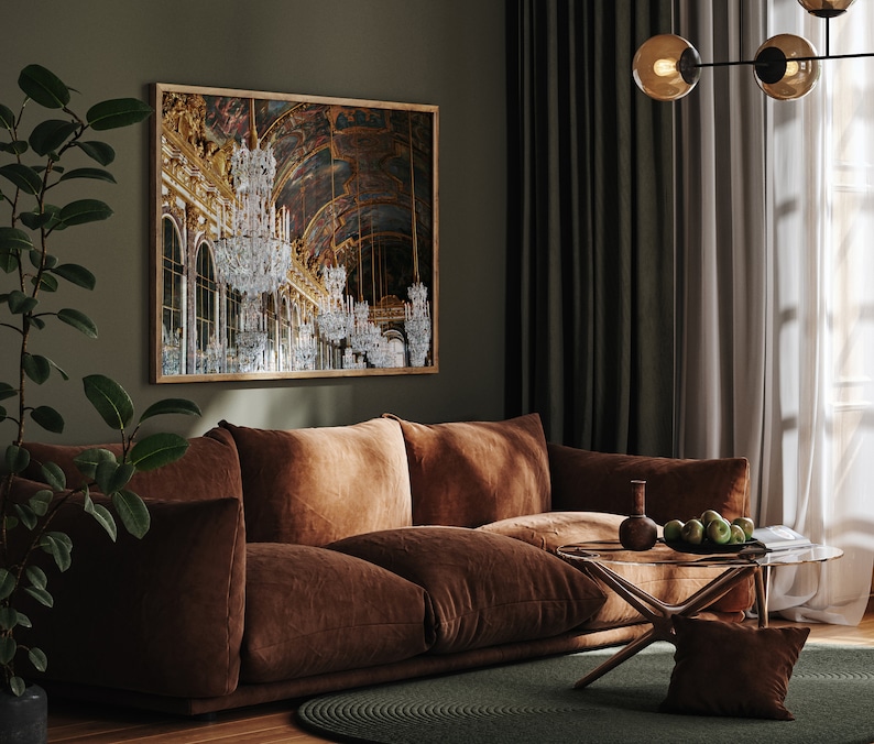 Puede incluir: Un sof&aacute; de terciopelo marr&oacute;n con una mesa de caf&eacute; de vidrio en una sala de estar con una gran impresi&oacute;n enmarcada de un gran sal&oacute;n con candelabros. La habitaci&oacute;n tiene paredes verdes y cortinas blancas.
