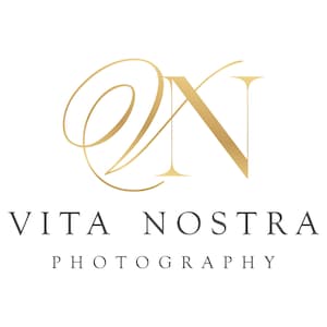 May include: A logo featuring a gold stylized script letter V intertwined with a serif letter N. Below the monogram, the text VITA NOSTRA appears in a dark gray serif font, followed by the word PHOTOGRAPHY in a smaller matching font.