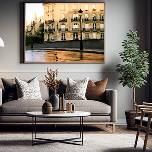 May include: A framed wall art print depicting a Parisian street scene with a stone building, wrought iron balconies, and a street lamp. The scene features a wet pavement reflecting warm light, with two small birds standing on the ground surface.