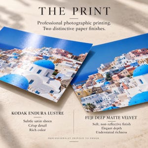 May include: Two photographic prints featuring a Greek island landscape with white buildings and blue domes. Text includes THE PRINT, Professional photographic printing, Two distinctive paper finishes, KODAK ENDURA LUSTRE, Subtle satin sheen, Crisp detail, Rich color, FUJI DEEP MATTE VELVET, Soft, non-reflective finish, Elegant depth, Understated richness, PROFESSIONALLY PRINTED TO ORDER.