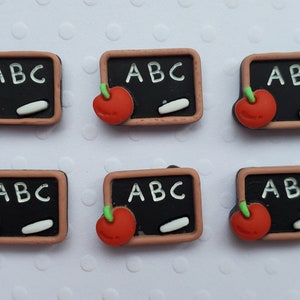 May include: Six small, brown, wooden-framed chalkboards with a red apple and a white piece of chalk on each. The chalkboards are all labeled "ABC".
