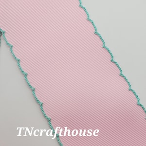 May include: Pink grosgrain ribbon with a ribbed texture, edged with a teal scalloped trim. The text "TNcrafthouse" is printed in white on the lower left side. This ribbon is suitable for crafts and gift wrapping.
