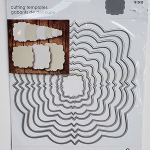 May include: A set of nine metal die-cutting templates in the shape of nested, ornate frames. The templates are silver and have a white background. The packaging includes the text "cutting templates" and "gabarits de découpe".