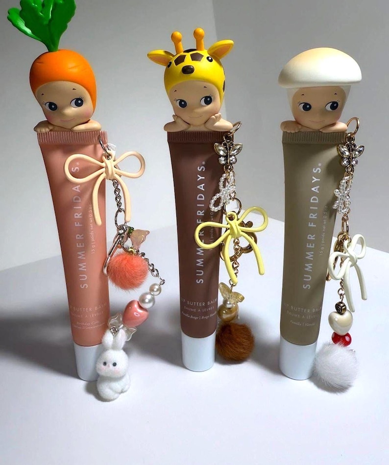以下が含まれることがあります： Summer Fridays Butter Balmのリップバームチューブ3本。それぞれユニークなフィギュアとチャームで飾られています。1つはニンジンをかぶったフィギュア、もう1つはキリン、最後はキノコです。各チューブには、ウサギ、蝶、リボンなど、異なるチャームが付いています。