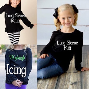 May include: Three girls wearing black long-sleeve shirts with different styles. The first shirt has a ruffle at the bottom and says "Long Sleeve Ruffle". The second shirt says "Long Sleeve Puff". The third shirt has a ruffle at the cuffs and says "Kyleigh Icing".