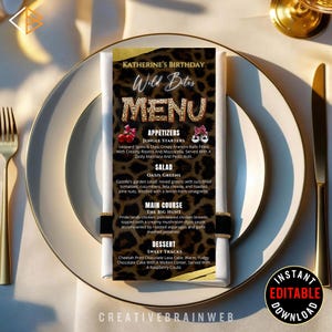 Könnte beinhalten: Eine Menükarte mit Leopardenmuster, mit dem Text "Wild Bites" und einer Liste von Vorspeisen, Salat, Hauptgericht und Dessert-Optionen. Das Menü befindet sich auf einem weißen Teller mit goldenem Besteck und einem Serviettenring.