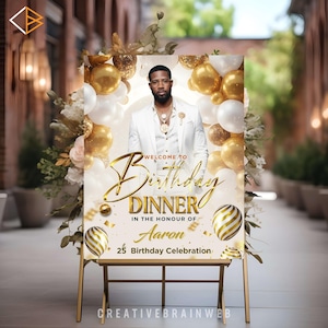 Puede incluir: Un letrero de bienvenida con marco dorado para una cena de cumpleaños, con un hombre con traje blanco. El letrero incluye globos dorados y blancos, detalles florales y el texto "Welcome to Birthday Dinner in the Honour of Aaron 25 Birthday Celebration."