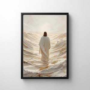 Op de afbeelding: Ingelijste kunstdruk met een figuur in een witte jurk die door een zee van getextureerde, crèmekleurige golven loopt. De figuur is van achteren te zien, met lang bruin haar. De achtergrond is een zacht, helder licht.