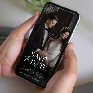 Könnte beinhalten: Ein Smartphone zeigt eine Hochzeitsankündigung. Der Bildschirm zeigt ein formelles Porträt eines Paares mit dem Text "SAVE THE DATE" in eleganter Schrift. Die Namen "Scarlett & Anderson" werden ebenfalls angezeigt, mit dem Satz "ARE GETTING MARRIED" darunter.