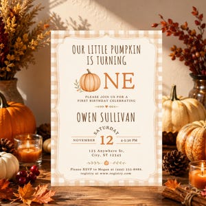May include: A rectangular birthday invitation card with a beige and white gingham border. The text reads: Our little pumpkin is turning one, Owen Sullivan, Saturday November 12, 4:30 PM, 123 Anywhere St, City, ST 12345, RSVP to Megan at (444) 333-8989, registry at www.registry.com.