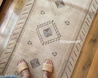 May include: Beige and gray patterned runner rug with geometric designs. The rug features a central diamond pattern and a border with zigzag and rectangular shapes. The text "ZSCarpetsIN" is visible on the rug. Woven sandals are visible on the rug.