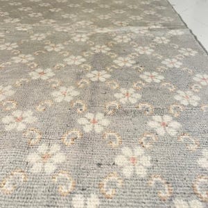 Tapete Oushak com estampa floral, em lã de alta qualidade, nas cores cinza e bege, feito à mão. Moderno e aconchegante, ideal para quarto e sala de jantar. Disponível nos tamanhos 9x12, 10x14 e 12x15 (tamanhos personalizados).