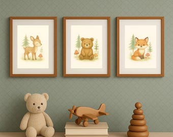 May include: Three framed art prints depicting woodland creatures: a deer, a bear, and a fox. Each print has a light background with trees and mushrooms. A stuffed bear, wooden aeroplane, and stacking toy sit below the prints.