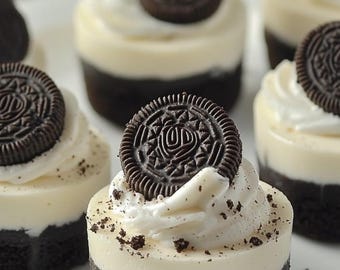 May include: Miniature desserts with a dark chocolate cookie base, a creamy white filling, and a dark chocolate cookie on top. The desserts are arranged on a white plate, with cookie crumbs scattered around.