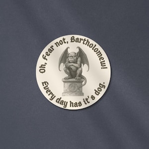 May include: A round sticker with a gargoyle illustration. The gargoyle is perched on a pedestal, with the text "Oh, Fear not, Bartholomew! Every day has it's dog." in a circular pattern around the image.