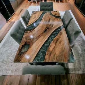 May include: A wooden dining table with a river-like design made of dark resin. The table is surrounded by six gray upholstered chairs. The table's dimensions are approximately 72 inches long and 36 inches wide.