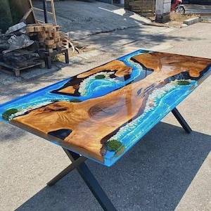 Könnte beinhalten: Ein rechteckiger Holztisch mit einem blauen Epoxidharz-Flussdesign. Der Tisch hat eine natürliche Holzmaserung mit glänzendem Finish und schwarzen Metallbeinen. Die Abmessungen betragen ca. 183 cm lang, 91 cm breit und 76 cm hoch.