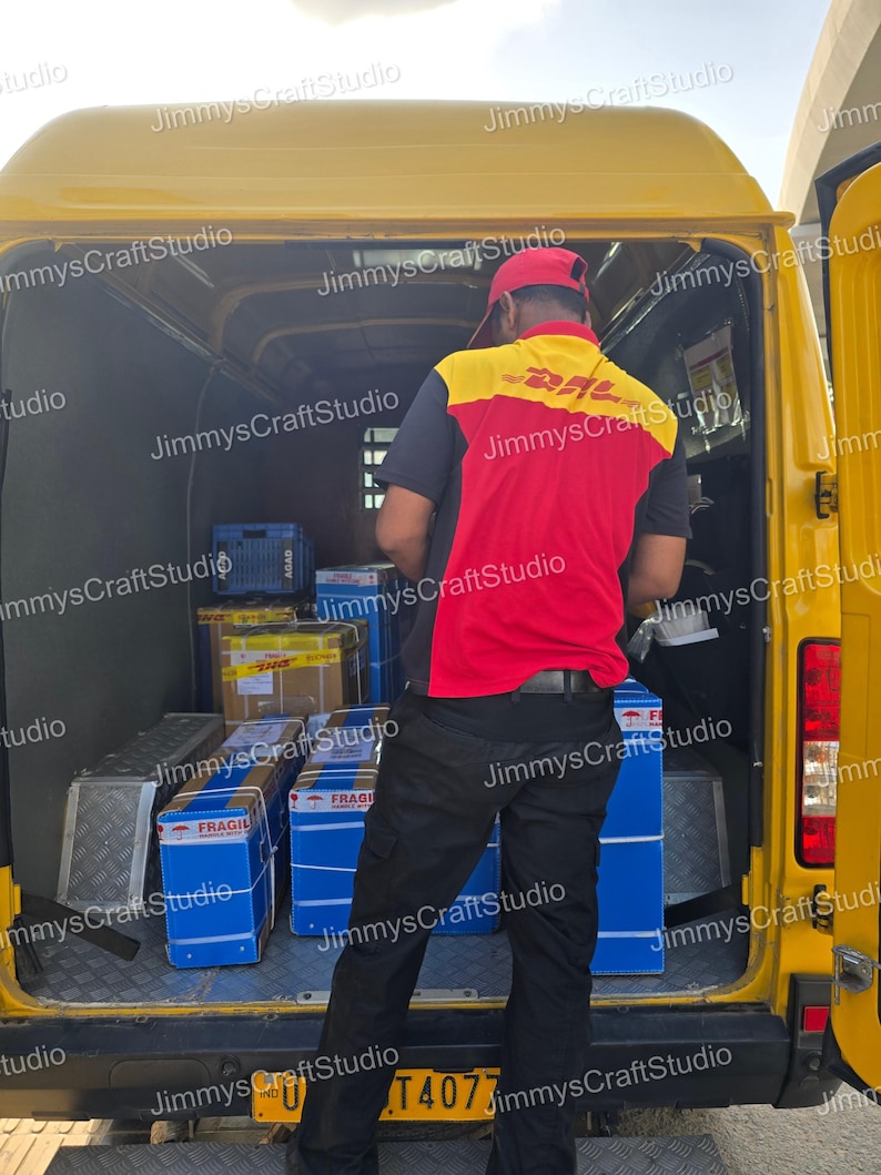 May include: A yellow DHL delivery van with the back door open, revealing packages and a delivery person. The person is wearing a red and yellow DHL uniform and a red cap. Blue boxes labeled "FRAGILE" are visible.
