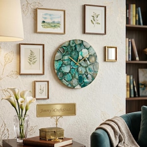 Può includere: Un orologio da parete circolare composto da un mosaico di fette di agata color verde acqua con lancette dorate. Il quadrante presenta un motivo in pietra naturale con sfumature di blu, verde e bianco, racchiuso in una sottile cornice dorata.