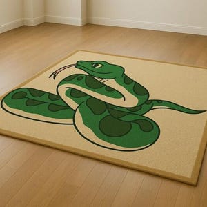May include: A rectangular rug with a cartoon snake design. The snake is green with dark green spots, a forked tongue, and is coiled on a beige background. The rug has a brown border and is on a wooden floor.