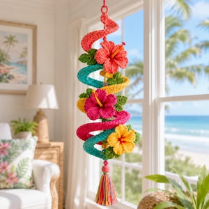 May include: A hanging spiral decoration crafted from crochet yarn, featuring vibrant red, pink, and yellow hibiscus flowers interspersed with green leaves. The structure is suspended by a loop and finished at the bottom with a multi-colored tassel.