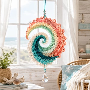 May include: A spiral-shaped crochet hanging ornament featuring a gradient of colors including coral, yellow, light green, and teal. The piece is suspended by a teal cord and features a clear, faceted teardrop crystal hanging from the bottom center.