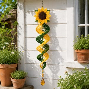 May include: A crochet sunflower hanging decoration featuring a large yellow and brown flower head attached to a long, spiraling green and yellow yarn tail. The bottom of the spiral is finished with a series of small amber beads and a teardrop crystal.
