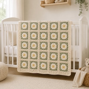 May include: A crochet blanket featuring a repeating pattern of square motifs. Each square displays a central yellow flower with white petals, framed by a sage green border and joined together with a cream-colored yarn edge throughout the design.