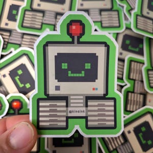 May include: A green and grey pixel art sticker of a robot with a computer screen for a head. The robot has a red antenna and a friendly face with green eyes. The sticker has the text "@kinalnk" on the bottom.