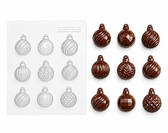 May include: A clear plastic mold tray featuring nine distinct spherical ornament cavities with various embossed patterns, accompanied by nine corresponding dark brown chocolate ornaments molded into the same festive bauble shapes.