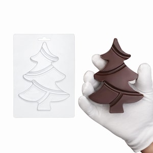 Puede incluir: Un molde rectangular de plástico transparente con forma de árbol de Navidad en relieve con líneas diagonales, junto a una figura de árbol de Navidad de chocolate marrón oscuro que coincide con el diseño del molde y muestra el resultado.
