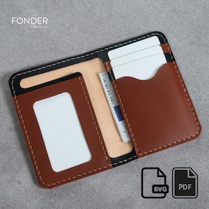 May include: Open brown and black leather wallet with white stitching. The wallet features multiple card slots and a clear ID window. The brand name "FONDER" is visible. The wallet is open, showing white cards and a bank note.