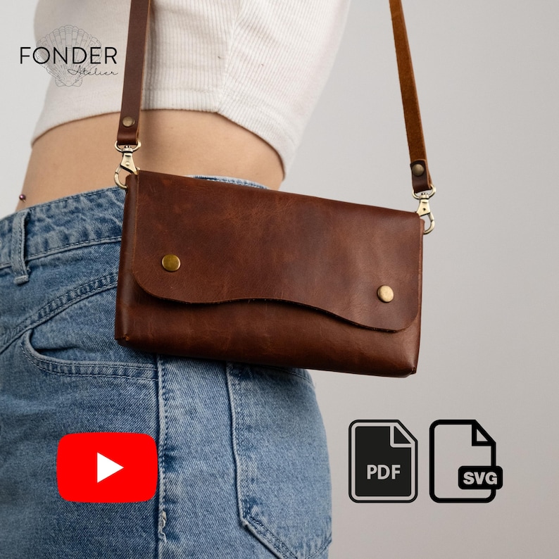 Peut inclure: Un sac bandouli&egrave;re en cuir marron avec un rabat et une longue bandouli&egrave;re r&eacute;glable. Le sac a une fermeture &agrave; bouton et des d&eacute;tails dor&eacute;s. Le nom de la marque "FONDER Atelier" est visible en haut &agrave; gauche.