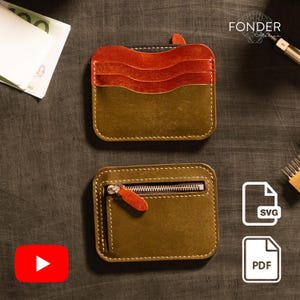 May include: Two leather wallets. One is olive green and orange with card slots. The other is olive green with a zipper and orange pull. Both have white stitching. The wallets are on a dark surface.