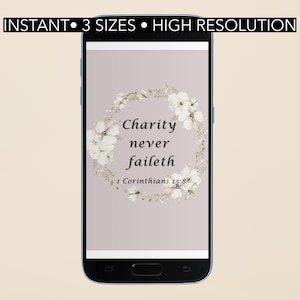 May include: A smartphone displays a digital print with the text "Charity never faileth" surrounded by a floral wreath. The words "INSTANT • 3 SIZES • HIGH RESOLUTION" are at the top. The background is a muted mauve color.