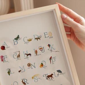 Close-up style view of the vintage nursery abc poster featuring letter details and soft muted tones, designed to feel timeless and cozy. A sweet alphabet chart for a cottagecore nursery or sage green nursery, great for nursery wall art and wall art kids rooms. Works as playroom wall art, playroom wall decor, abcs decor, and alphabet poster.