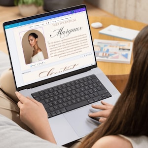 May include: A laptop screen showing a webpage titled "Meet Your Stylist" with the name "Margaux" in cursive. The page features a photo of a woman and text about her services. The laptop is on someone's lap.