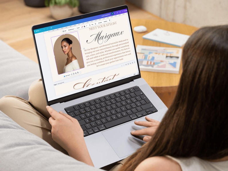 May include: A laptop screen showing a webpage titled "Meet Your Stylist" with the name "Margaux" in cursive. The page features a photo of a woman and text about her services. The laptop is on someone's lap.