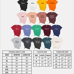 Pu&ograve; includere: Sono esposte diverse magliette in vari colori, tra cui nero, bianco e rosso. L'immagine include anche una tabella delle taglie per adulti unisex, giovani e bambini piccoli, con misure in centimetri.