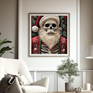 以下が含まれることがあります： 赤と緑のセーターとサンタ帽をかぶった骸骨のサンタクロースが描かれた額入りのプリント。アートワークは白いひげと口ひげを持っています。背景には緑の葉と赤いベリーが含まれています。プリントはリビングルームに表示されています。