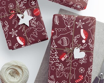 May include: Burgundy gift wrap with a white Christmas-themed pattern of reindeer, ornaments, and snowflakes. Each wrapped gift is tied with twine and a white tag. A spool of twine and scissors are also visible.