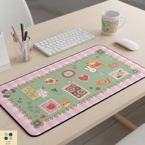 May include: A rectangular mouse pad with a green background and a pink gingham border. The pad features various cute illustrations, including a bunny, apple, heart, and stamps. A white keyboard, mouse, and mug are also on the desk.