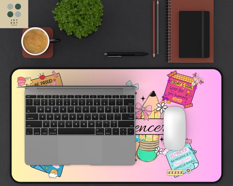 May include: A desk mat with a colorful design featuring the text "BE PROUD", "TODAY'S GOAL", and "REMINDER". The mat has a laptop, mouse, and other office supplies on top. The mat is approximately 30 inches long.