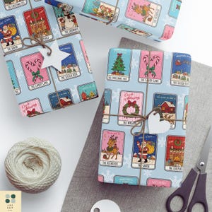 May include: Wrapped presents with light blue paper decorated with Christmas illustrations. The gifts are tied with twine and have heart-shaped tags. A ball of twine and scissors are also visible.