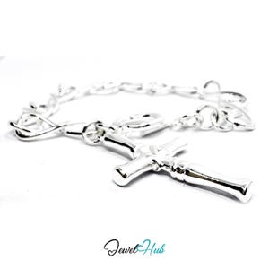 May include: A silver-colored bracelet with a cross pendant. The bracelet features a chain-link design and a prominent cross charm. The cross is detailed and has a polished finish, reflecting light. The jewelry is set against a white background.